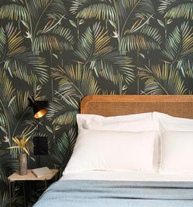 a bedroom with a bed with a tropical wallpaper at Antica Dimora Le Misure in Cervia