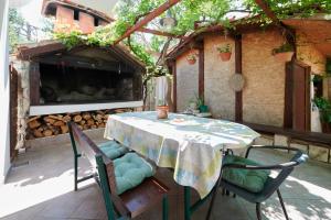 una mesa y sillas en un patio con chimenea en Guesthouse Aria, en Trogir