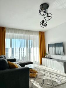 uma sala de estar com um sofá e uma televisão em Room44 - Apartment em Brasov