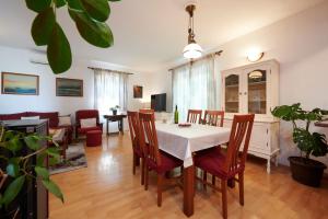 a dining room and living room with a table and chairs at Guesthouse Aria in Trogir