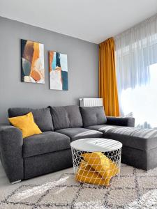 uma sala de estar com um sofá e uma mesa em Room44 - Apartment em Brasov
