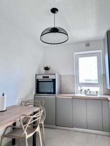 uma cozinha com uma mesa, um lavatório e um micro-ondas em Room44 - Apartment em Brasov