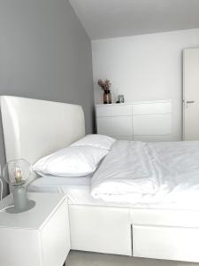 um quarto branco com uma cama branca com lençóis brancos em Room44 - Apartment em Brasov