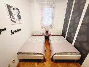 two beds in a small room with a window at Apartment Lucija in Split