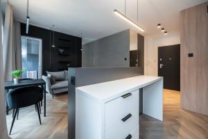 a kitchen with a white counter and a dining room at Apartament Piotrkowska 44 - studio in Łódź