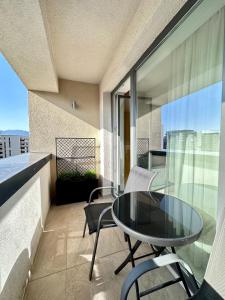 uma varanda com uma mesa de vidro e cadeiras em Room44 - Apartment em Brasov