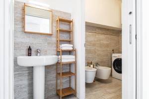 a bathroom with a sink and a washing machine at RELSTAY - Porta Romana - Large Studio in Milan