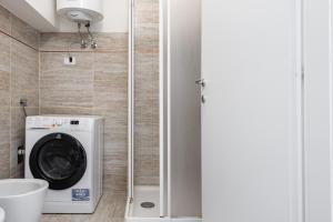 a washer and dryer in a small bathroom at RELSTAY - Porta Romana - Large Studio in Milan +2 photos