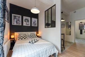 - une chambre avec un lit blanc et des murs noirs dans l'établissement Egée-Charmant Studio Centre Pont-Audemer, à Pont-Audemer
