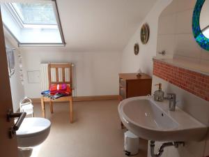 een badkamer met een wastafel, een toilet en een raam bij Ferienwohnungen Antonsruh im Kirnitzschtal in Sebnitz