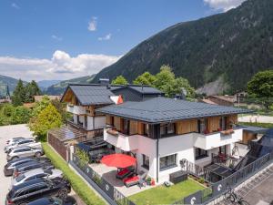 een groot huis met auto's geparkeerd op een parkeerplaats bij Appartements ALMA in Mayrhofen