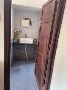 an open door to a bathroom with a sink at City Style Cottage in Surūrnagar