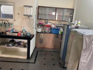 a kitchen with a refrigerator and a table in it at City Style Cottage in Surūrnagar