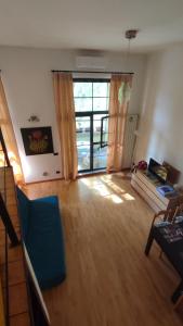 uma sala de estar com piso em madeira e uma grande janela em la casa di amy - loft corvetto em Milão