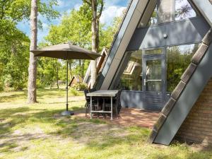 StramproyにあるSecluded Holiday Home in Limburg with a Terraceのテーブルと傘を持つ家