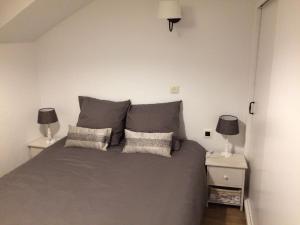 een slaapkamer met een grijs bed en 2 nachtkastjes bij Rêve de Poètes in Bagimont