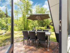 StramproyにあるSecluded Holiday Home in Limburg with a Terraceのパティオ(テーブル、椅子、パラソル付)