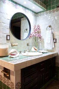 een badkamer met een wastafel en een spiegel bij AmazINN Places Casa Coyoacan in Mexico-Stad
