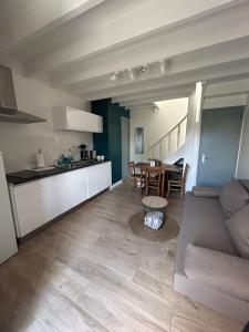 a kitchen and a living room with a couch and a table at L'escapade, Gîte calme au cœur de Clisson et proche de la Sèvre in Clisson