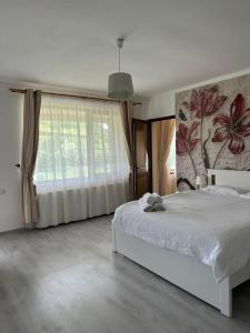 a bedroom with a white bed and a large window at Casa Mardar in Oradea