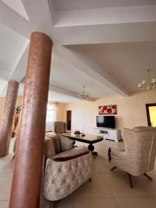 a living room with a column and chairs and a table at Casa Mardar in Oradea