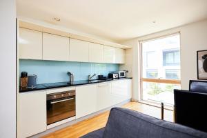 una cocina con armarios blancos y una ventana en The Jasper Walk Escape - Charming 2BDR Flat with Balcony, en Londres