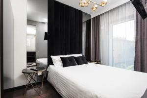 sypialnia z białym łóżkiem i czarną ścianą w obiekcie City of the Kings - Onyks Apartment w Krakowie