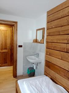 ein Bad mit einem Waschbecken und ein Bett in einem Zimmer in der Unterkunft Horská bouda Krakonoš in Černý Důl