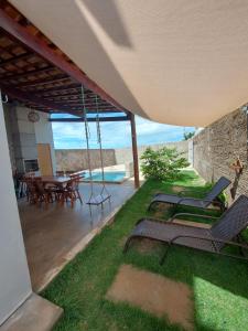 un patio con sillas y una mesa con vistas al océano en casAmar Gostoso, en São Miguel do Gostoso