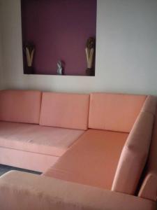 un divano rosa in un soggiorno con parete viola di Vromolithos apartments #4 a Vromolithos