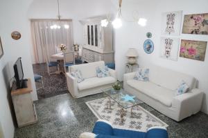 ein Wohnzimmer mit 2 weißen Sofas und einem Tisch in der Unterkunft La casa del nonno in Borgagne