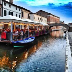 a boat filled with people riding on a river at Locanda della Pescheria in Comacchio