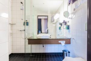 a bathroom with a sink and a shower at Clarion Hotel Post in Gothenburg