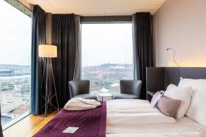 a hotel room with a bed and a large window at Clarion Hotel Post in Gothenburg