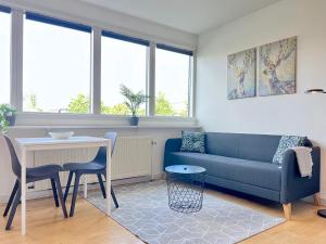 a living room with a blue couch and a table at Studio Apartment In Glostrup, Hovedvejen 70, 3 in Glostrup