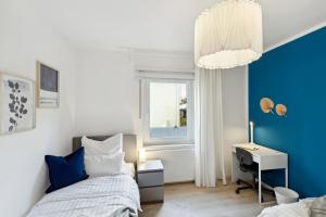 a bedroom with a bed and a desk and a window at AT WEINMEISTER - Großzügigkeit & Ruhe in Gütersloh