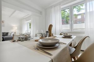 居特斯洛的住宿－Großzügige & Moderne Wohnung - Wifi - Terrasse，白色的用餐室配有桌椅