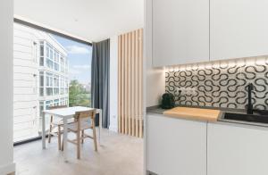 a kitchen with white cabinets and a table at Stayaday Apartments Albufera in Madrid