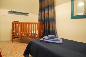 Una cuna en una habitación con una toalla azul en una cama en La casa del nonno, en Borgagne