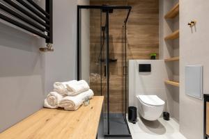 uma casa de banho com um chuveiro e um WC. em Homewell Apartments Poznańska em Poznań