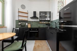 una cocina con electrodomésticos negros y una mesa con sillas. en Homewell Apartments Poznańska, en Poznan