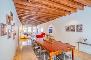 une grande salle à manger avec une table et des chaises en bois dans l'établissement Sartor Apartment with Canal View and Private Court, à Venise