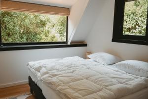 a bed in a room with a large window at Boshuisje Rekem - Topo in Lanaken
