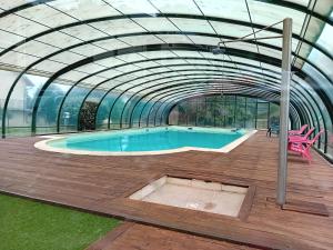 een zwembad in een glazen kas bij Appartement 39 M² 2/4 personnes avec piscine in Aspin-en-Lavedan