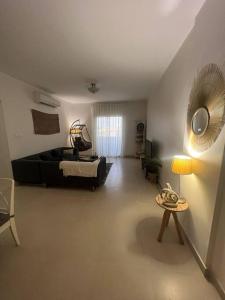 ein Wohnzimmer mit einem schwarzen Sofa und einem Tisch in der Unterkunft شقة الاحلام in King Abdullah Economic City