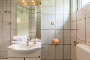 La salle de bains blanche est pourvue d'un lavabo et d'une douche. dans l'établissement Apartments Agneza Tucepi, à Tučepi