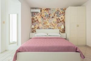 una camera da letto con un grande letto e carta da parati floreale di Apartments Agneza Tucepi a Tučepi