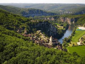 una vista aerea di una piccola città vicino a un fiume di La Pinay - Une petite maison cosy avec spa & cheminée a Lacave
