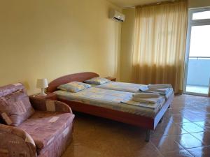 sypialnia z łóżkiem i kanapą w obiekcie Family hotel Summer w Rawdzie