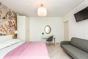 - une chambre avec un lit et un canapé dans l'établissement Apartments Agneza Tucepi, à Tučepi